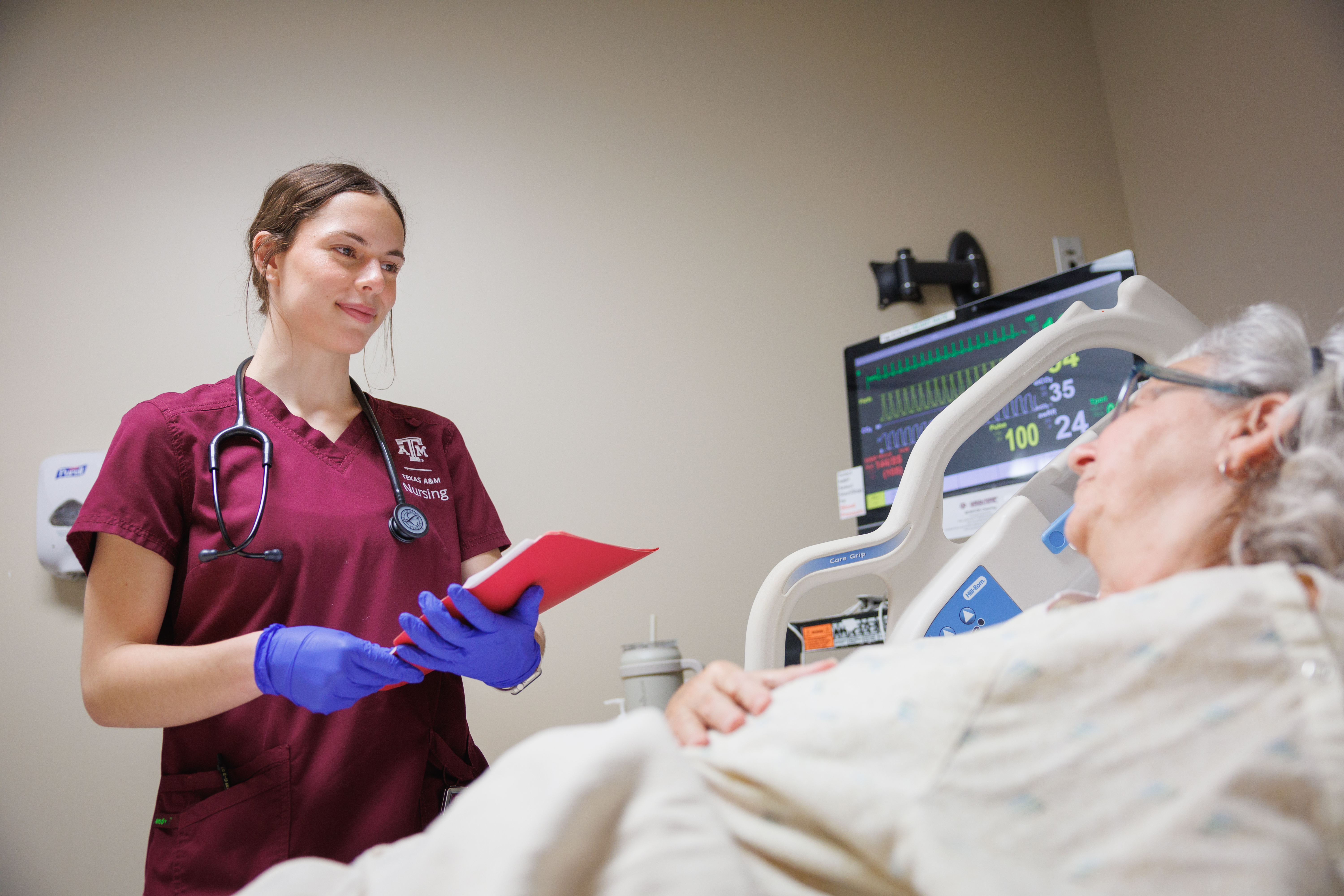 Nursing student smiling at a patient.