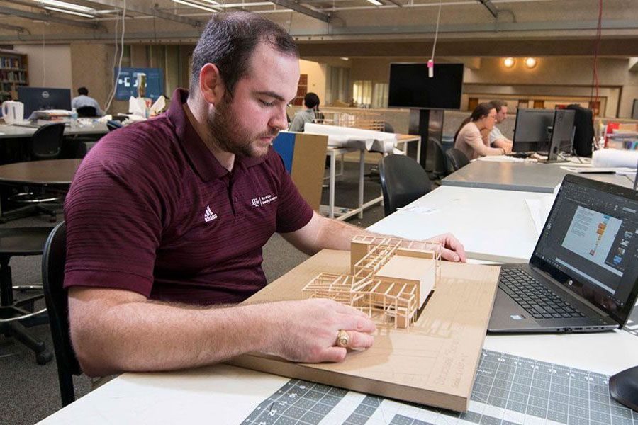 College of Architecture students looks over his class project of a building model