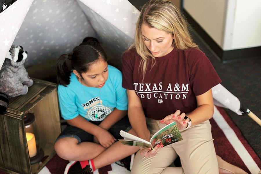 College of Education and Human Development student reads to a child