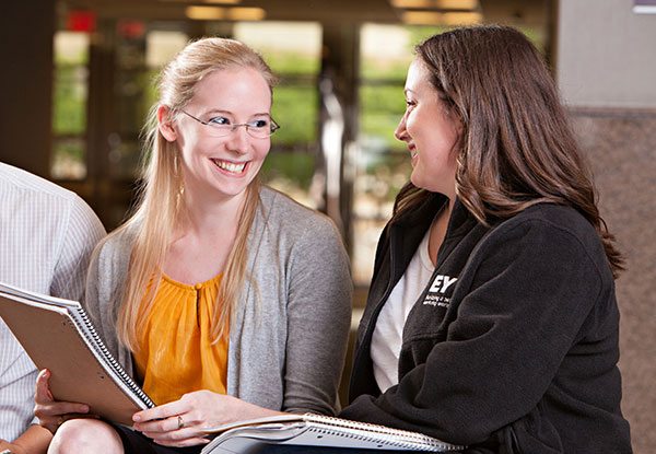 Mays Business students smiling while working through class assignments