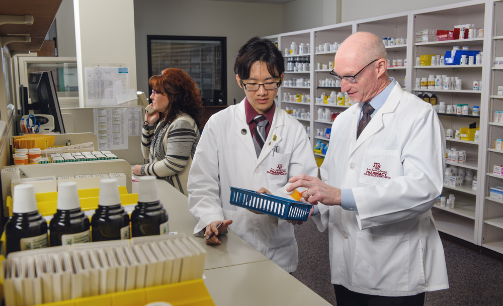 Irma Lerma Rangel College of Pharmacy student checks his work in the clinic with a professor