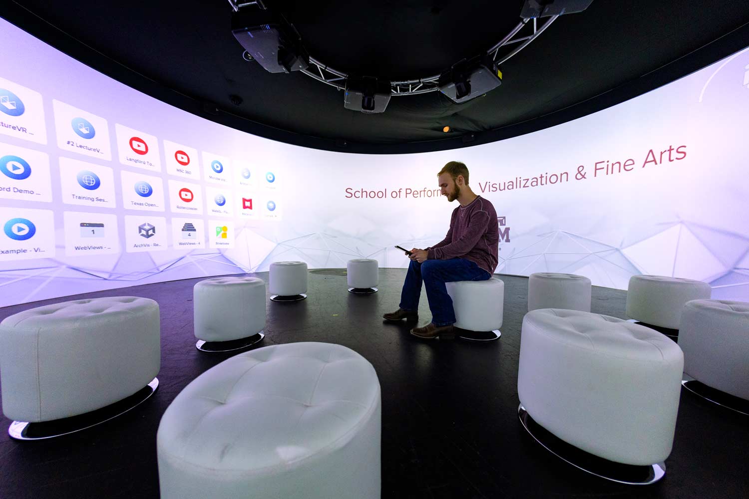 Student sitting in the immersive igloo cylinder with a 360-degree screen.