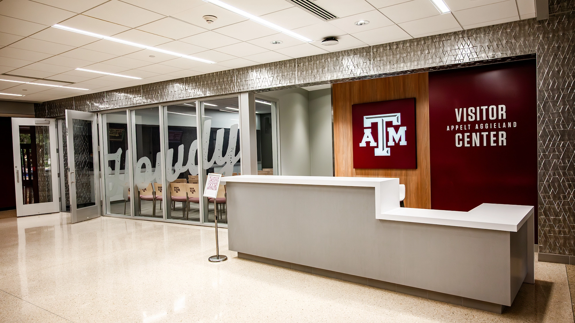 A modern interior of the Texas A&M Visitor Center, featuring a reception desk and welcoming seating area.